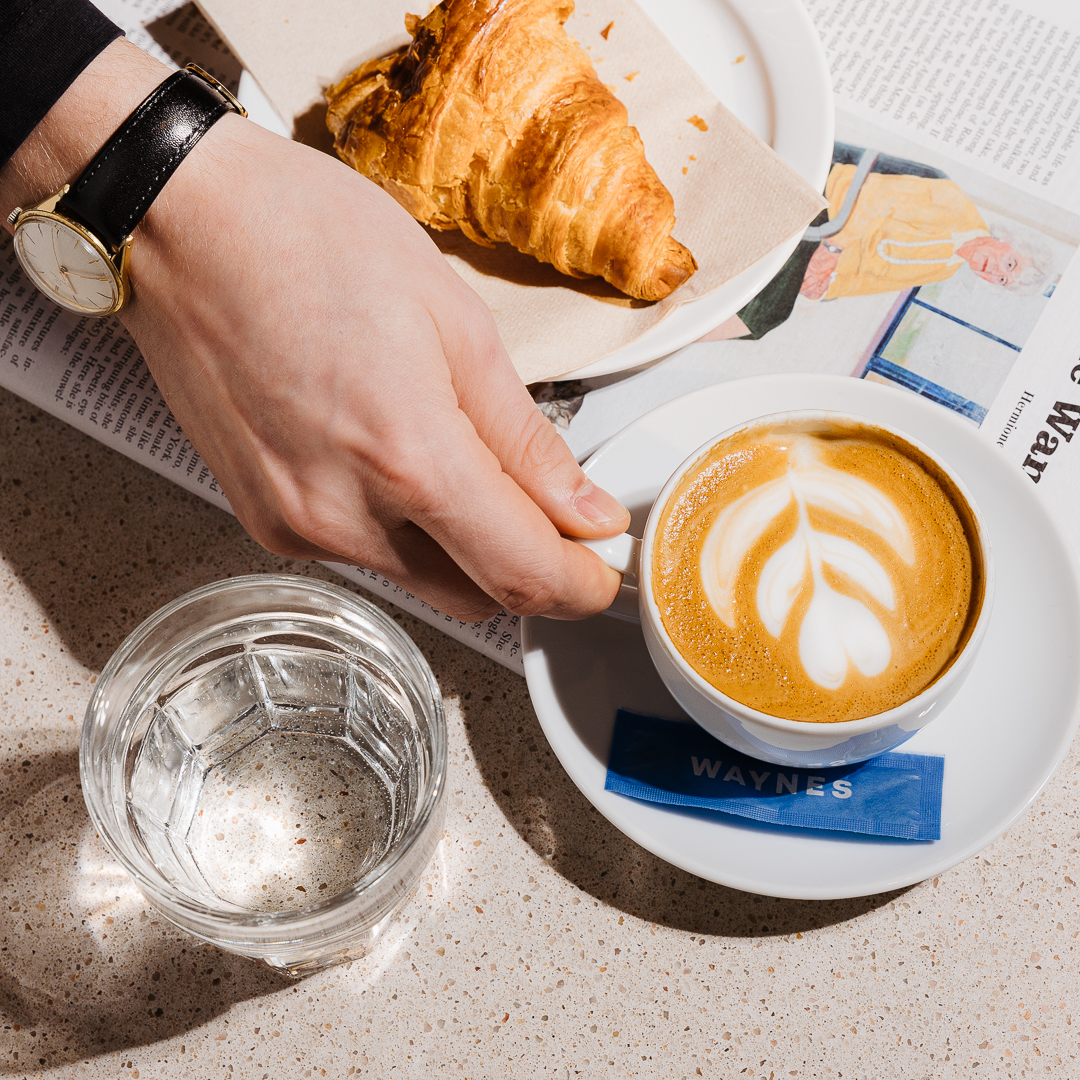 Kaffe, croissant och ett glas vatten